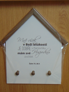 Věšák na klíče ve tvaru domu s biblickým textem.